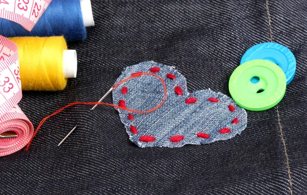 Patch a forma di cuore su jeans con fili e bottoni primo piano — Foto Stock