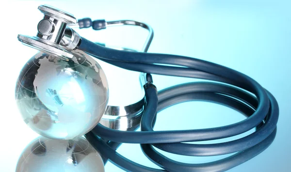 Glob i stetoskop na niebiesko — Zdjęcie stockowe
