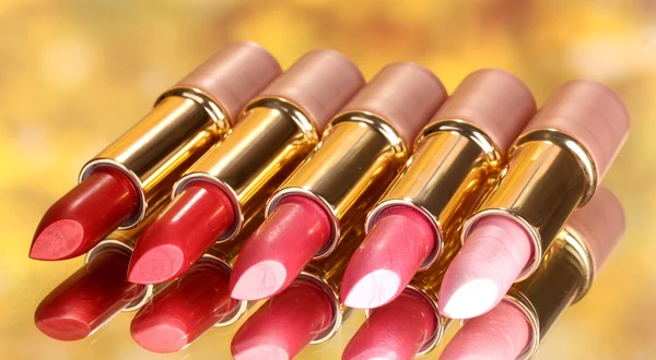 Beautiful lipsticks on yellow background — Stock Photo, Image