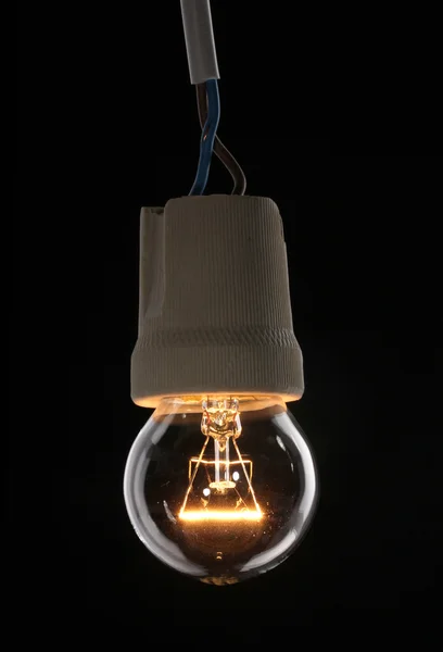 A lit light bulb on black background — Stock Photo, Image