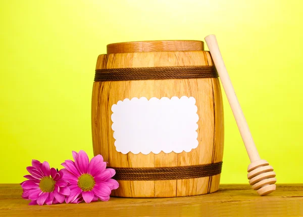 Sweet honey in barrel with drizzler on wooden table on green background — Stock Photo, Image