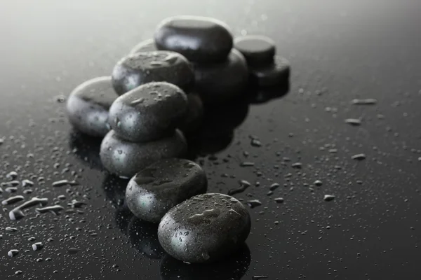Piedras de spa con gotas sobre fondo gris —  Fotos de Stock