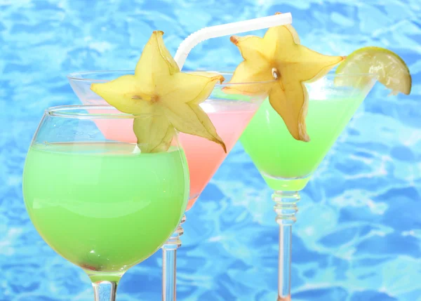 Glasses of cocktails on blue sea background