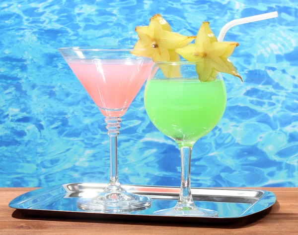Brýle koktejlů na dřevěný stůl na pozadí modré moře — Stock fotografie