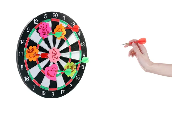 A hand throwing a dart at a sticker on darts on white background — Stock Photo, Image