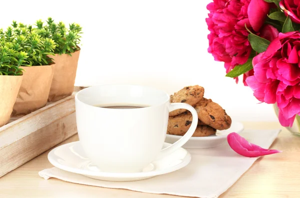 Šálek kávy, soubory cookie a květiny na stole v kavárně — Stock fotografie