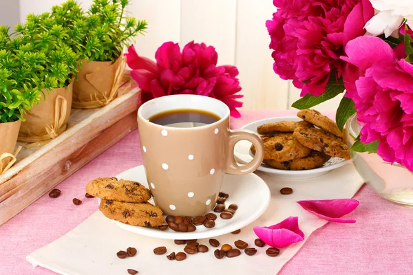 ถ้วยกาแฟ คุกกี้ และดอกไม้บนโต๊ะในคาเฟ่ — ภาพถ่ายสต็อก