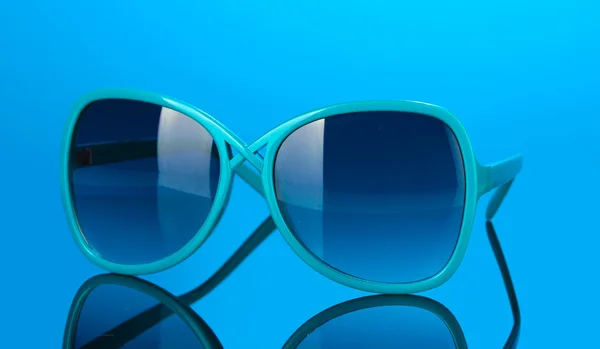 Μοντέρνες γυναίκες μπλε γυαλιά ηλίου σε φωτεινές πολύχρωμες φόντο — Φωτογραφία Αρχείου