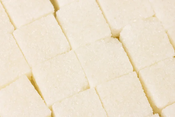 Gros plan sur fond blanc de sucre en morceaux — Photo
