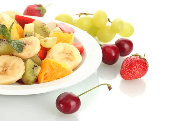 Салат из свежих фруктов на тарелке и ягоды, изолированные на белом — стоковое фото