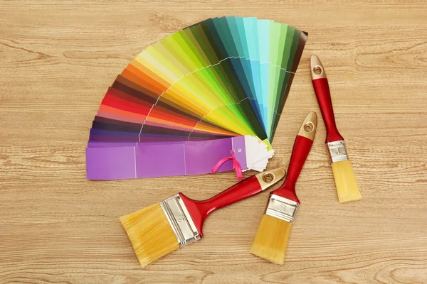 Пензлі фарби і яскрава палітра кольорів на дерев'яному фоні — стокове фото