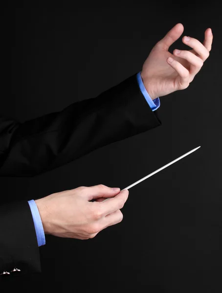 Muziek dirigent handen met stokje geïsoleerd op zwart — Stockfoto