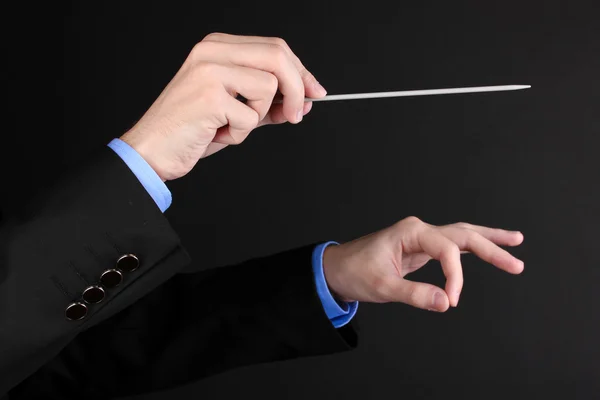 Mãos de maestro de música com bastão isolado em preto — Fotografia de Stock