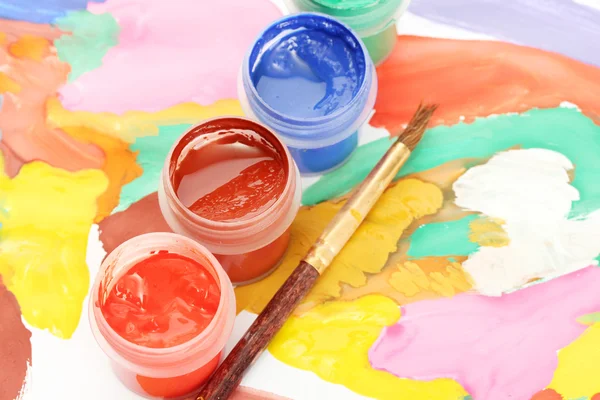 Jars with colorful gouache on a bright picture close-up — Stock Photo, Image
