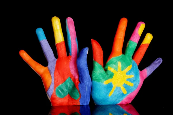 Brightly colored hands on black background close-up — Stock Photo, Image