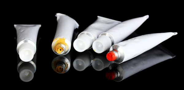 Tubes with colorful watercolors on black background close-up — Stock Photo, Image