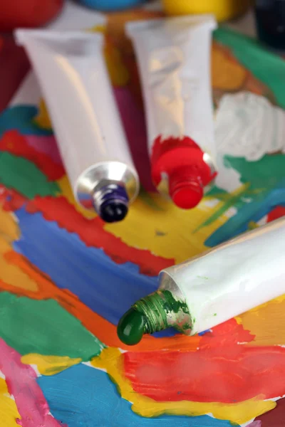 Tubes with colorful watercolor on colorful image close-up — Stock Photo, Image