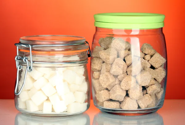Glas mit braunem Rohrzuckerklumpen und Zuckerdose mit weißem Zuckerklumpen isoliert auf weißem — Stockfoto