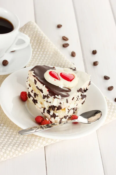Söt kaka med choklad på plattan och kopp kaffe på träbord — Stockfoto