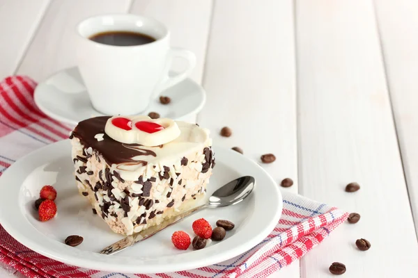 प्लेटवर चॉकलेट आणि लाकडी टेबलवर कॉफी कप सह गोड केक — स्टॉक फोटो, इमेज