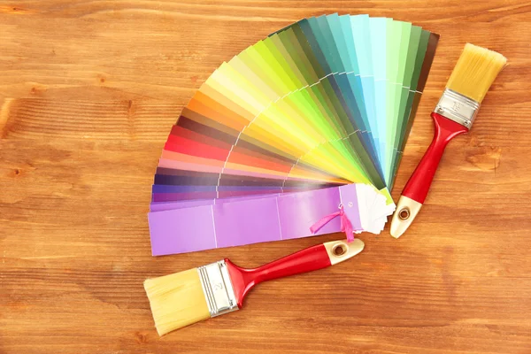Pinsel und helle Farbpalette auf Holzgrund — Stockfoto