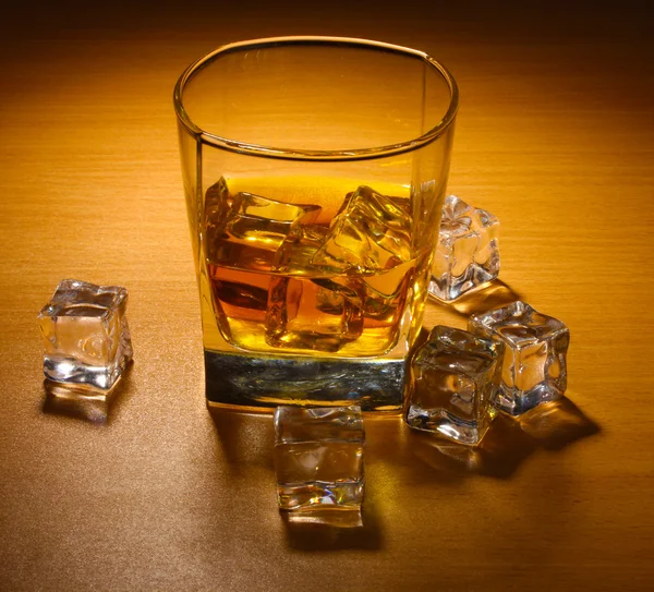 Glas scotch whisky en ijs op houten tafel — Stockfoto