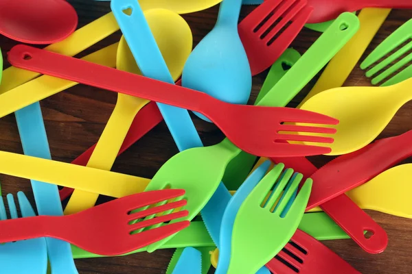 Plástico brilhante utensílios de mesa descartáveis em fundo de madeira close-up — Fotografia de Stock