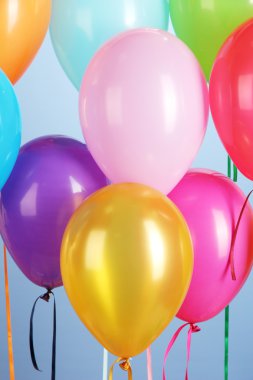 Colorful balloons on blue background close-up clipart