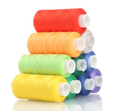 Pyramid of many-coloured bobbins of thread isolated on white clipart