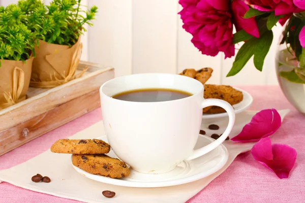 Tazza di caffè, biscotti e fiori sul tavolo in caffè — Foto Stock