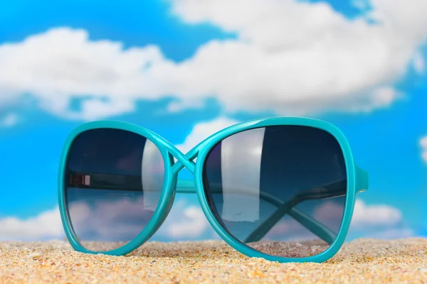 Elegant women's sunglasses at the beach — Stock Photo, Image