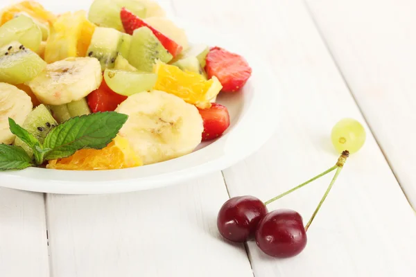 プレートと白の木製テーブル上の果実のフレッシュ フルーツのサラダ — ストック写真