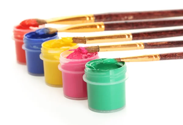 Brushes on the jars with colorful gouache on white background close-up — Stockfoto