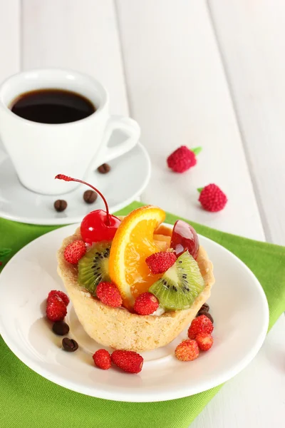 Pastel dulce con frutas en el plato y taza de café en la mesa de madera — Foto de Stock
