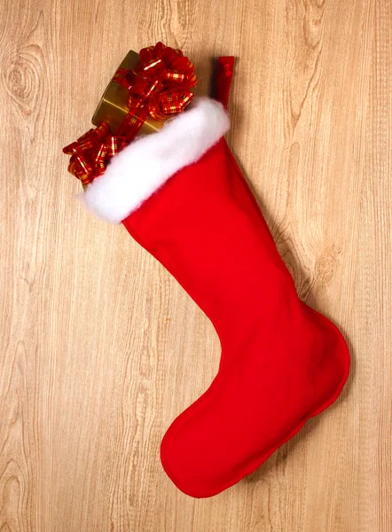 Calcetín de Navidad con regalos sobre fondo de madera — Foto de Stock