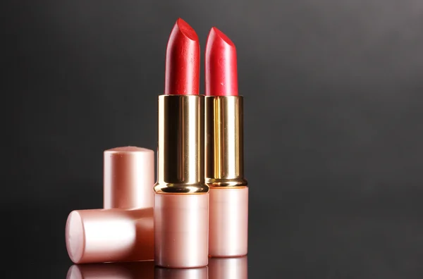 Mooie rode lippenstift op grijze achtergrond — Stockfoto