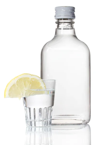 Flaska vodka och vinglas med citron isolerad på vit — Stockfoto