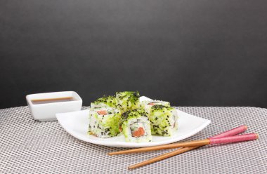 lezzetli rulo ile chopsticks gri mat gri arka plan üzerinde beyaz tabakta servis