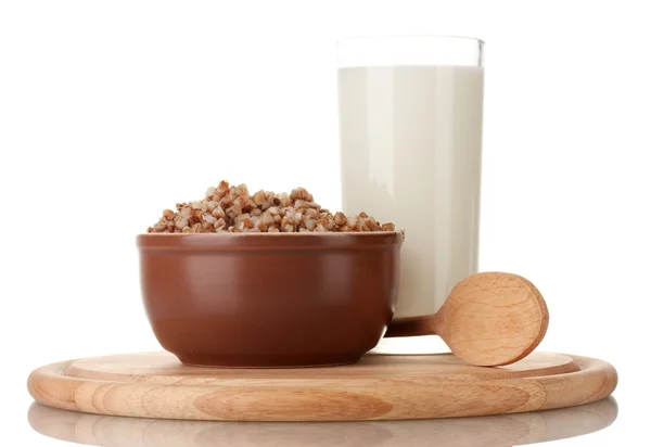 Boiled buckwheat in a brown bowl a glass of milk on a wooden board isolated on white — Stock Photo, Image