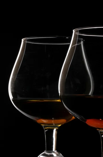 Two glasses of cognac on black background — Stock Photo, Image