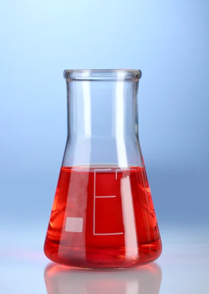青色の背景に反射と赤い液体のフラスコ — ストック写真
