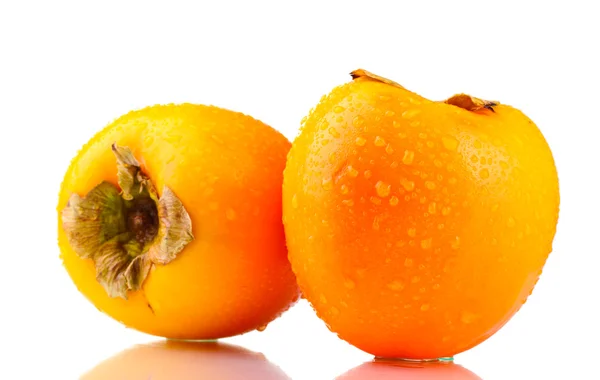 Två aptitretande sharonfrukt med droppar isolerad på vit — Stockfoto