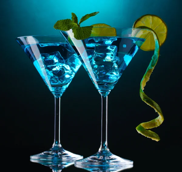 Голубой коктейль в бокалах для мартини на синем фоне — стоковое фото