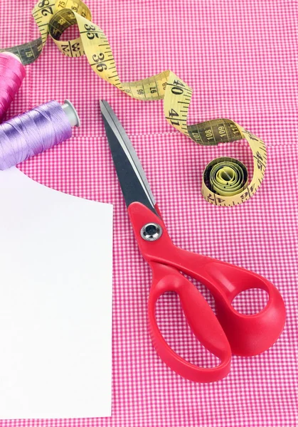 Scissors,threads, measuring tape and pattern on fabric close-up — Stock Photo, Image
