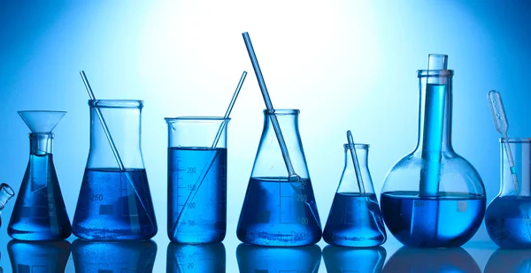 Test-tubes with blue liquid on blue background — Stock Photo, Image