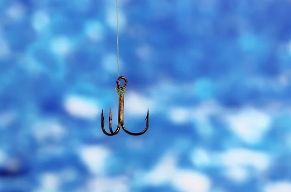 Treble fish hook on blue background — Stock Photo, Image