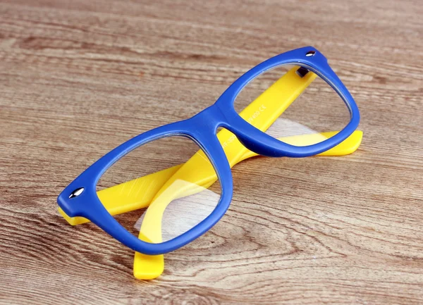 Krásné barevné brýle na dřevěné pozadí — Stock fotografie