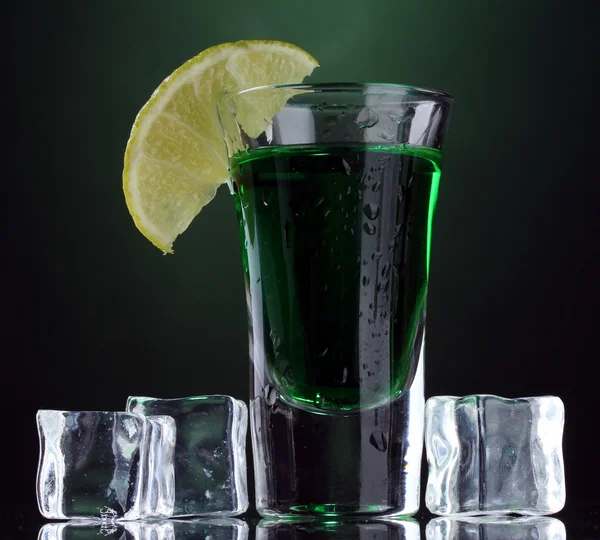 Склянка з абсентом, лайм і лід на зеленому фоні — стокове фото