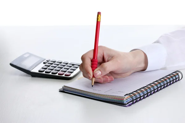 Mulheres mãos com lápis, caderno e calculadora isolado em branco — Fotografia de Stock