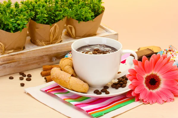 Ceașcă de cafea și boabe de gerbera, bețe de scorțișoară pe masă de lemn — Fotografie, imagine de stoc